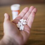 A hand holding a large amount of cyclobenzaprine pills.