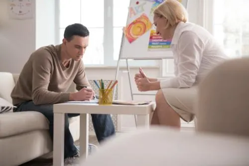 a man works with a therapist at an art therapy program in tampa