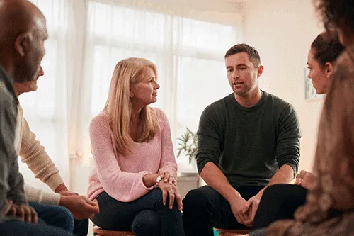 Folks sit and talk in group therapy during a drug and alcohol detox program