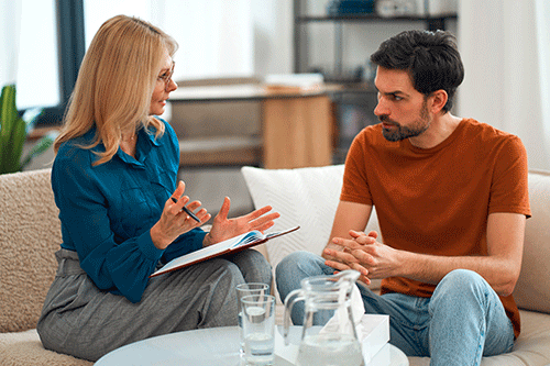 Man talks to doctor about trauma during PTSD treatment program