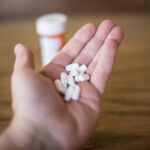 A hand holding a large amount of cyclobenzaprine pills.